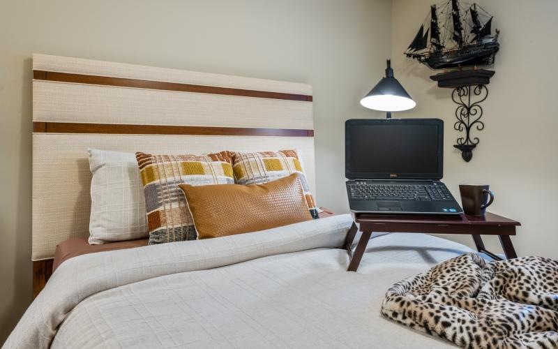 Laptop on a bed in Palmetto Pointe Apartment